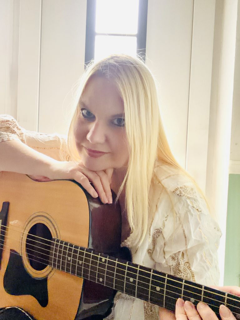 Kat with her acoustic guitar, a symbol of pure music without filter.